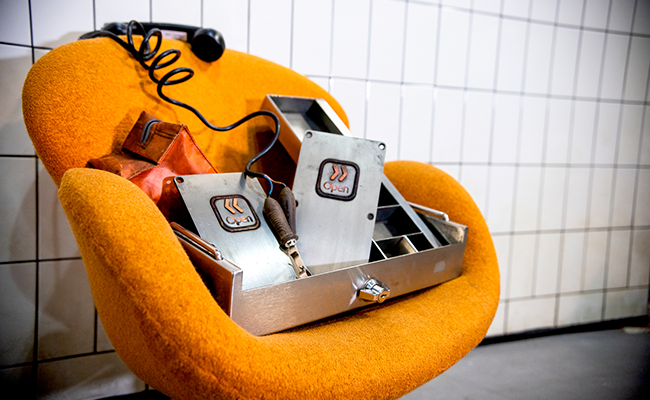 An orange chair with a metal money box, a telephone and two Jubilee line buttons